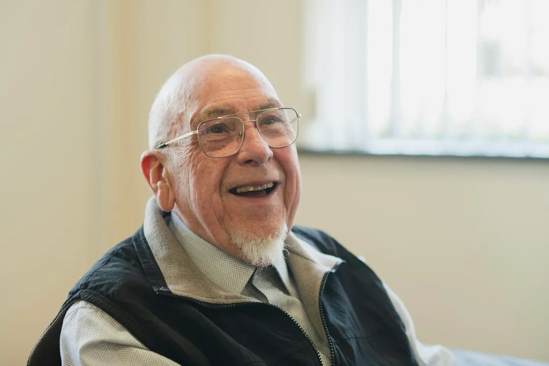 An older man laughing, with a full, healthy smile