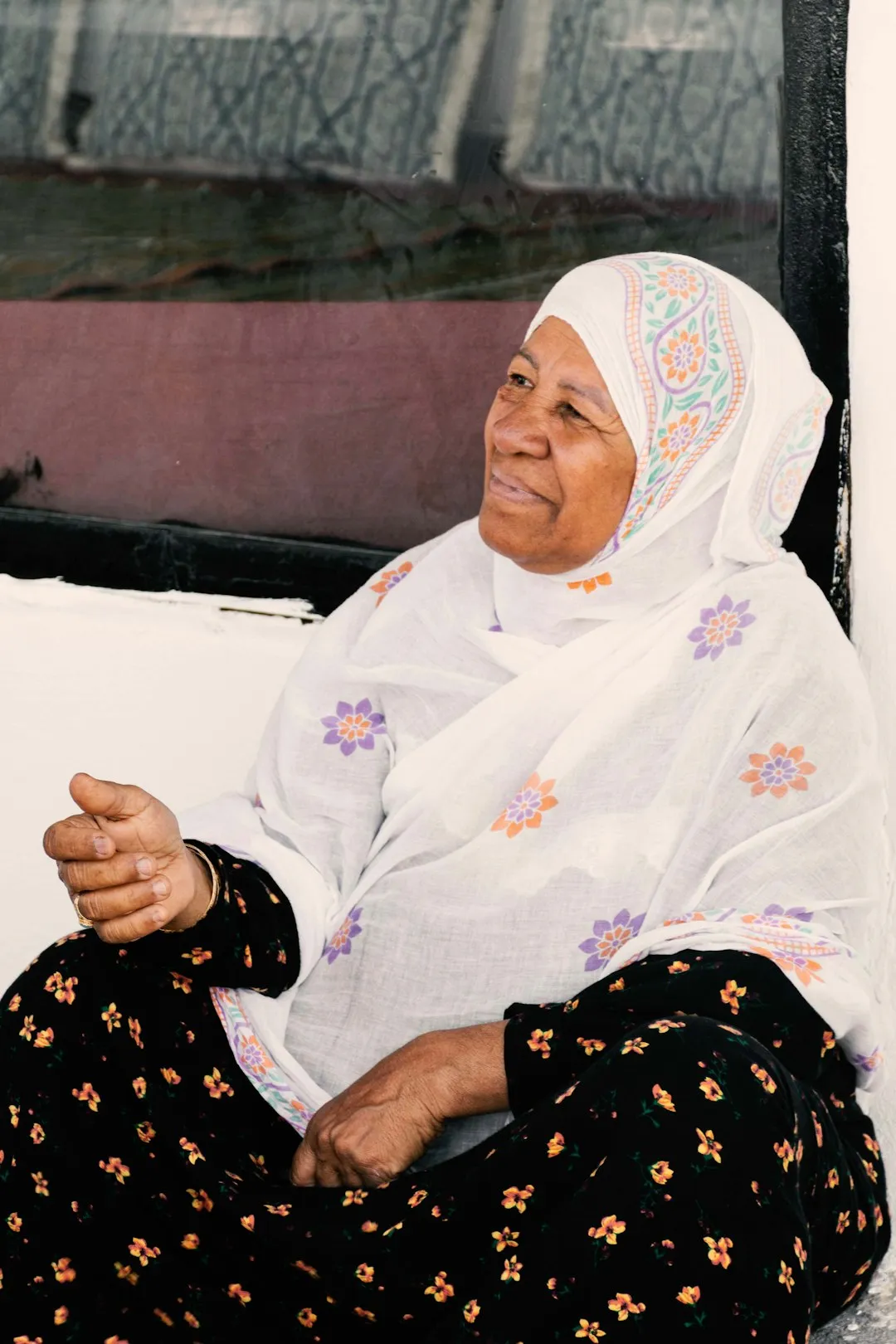 An older woman in a white headscarf, smiling